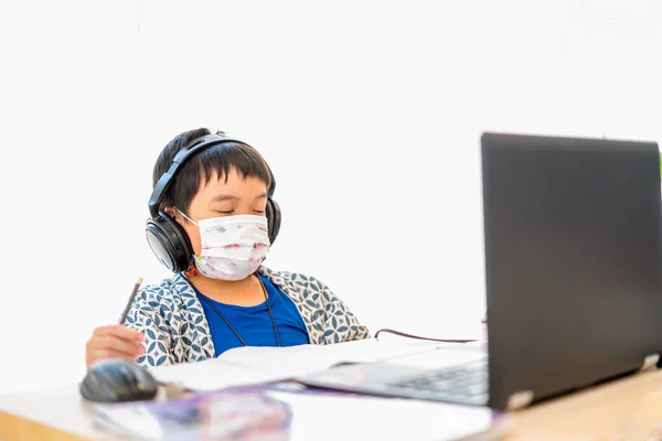 Asyalı çocuklar online çalışmaktan bıktılar, evde karantina salgını, evde eğitim, çevrimiçi eğitim, korona virüsü veya teknoloji konsepti sırasında online bilgisayar kullanarak evde çalışıyorlar.