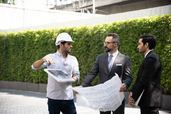 İş adamı ya da mal sahibi, inşaat halindeki güneş pili sistemi ya da enerji mühendisi projesinin mühendislik tasarımı için inşaat danışmanlarıyla görüşüyor. Temiz ve yeşil alternatif enerji kavramı.