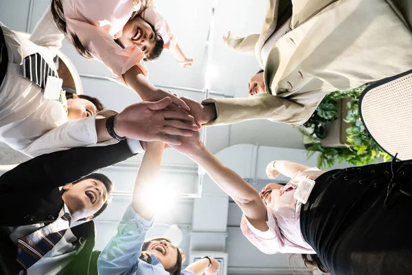 Genç takım yaratıcı ofiste yeni bir başlangıç için ellerini kaldırıyor, neşeli insanlar motivasyon veriyor, el ele odaklanıyor, ortak çalışma ve takım çalışması kavramına odaklanıyor, iş başarısı üzerine çalışıyor.