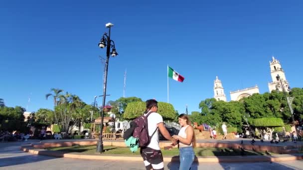 Happy Mexican young couple in love meeting in the park in front of Cathedral of Merida in Merida historic city center, the oldest cathedral in Latin America — Wideo stockowe