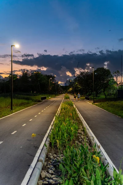 Bulutlu ve gün batımlı parkta koşu yolu