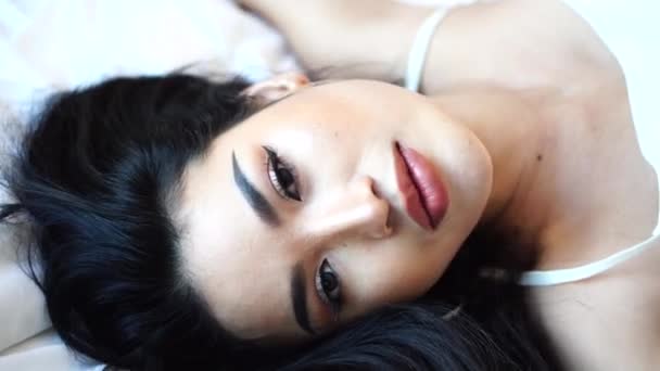Portrét krásné asijské ženy na posteli pózu na kameru, smyslný ženský model — Stock video