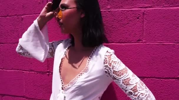 年轻的亚裔美国女模特站在粉红墙前拍照 — 图库视频影像