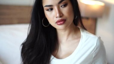 Çekici Asyalı Kadın Modeli 'nin portresi. Yatak odası 4k' de uzun saçlı poz veriyor.