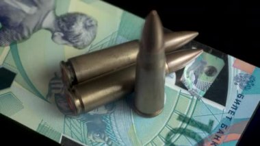 100 Rus Ruble banknotunda makineli tüfek mermileri. Savaş ve Ekonomi Konsepti, 4K 'yı Kapat