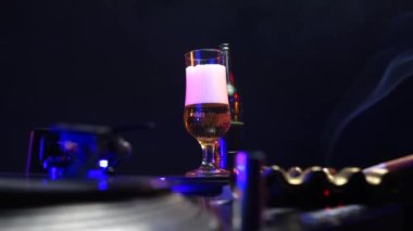 Glass of Beer, Cigarette Smoke, Spinning Vinyl Record and Disco Lights in 1980s Party, Close Up