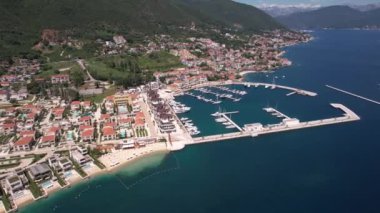 Karadağ 'ın Kumbor kentindeki Portonovi tatil beldesinin havadan görüntüsü. Güneşli günde Marina ve Lüks Sahil Binaları, İHA 4K 'yı kuruyor.