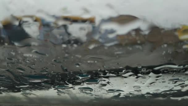 Krople Deszczu Spadają Szybę Spływają Niej Zamazane Domy Przejeżdżające Samochody — Wideo stockowe