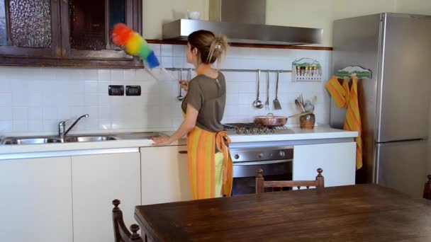 Jovem mulher limpando a mobília na cozinha — Vídeo de Stock