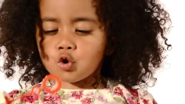 Funny mixed race black and latino brazilian little girl isolated blowing soap bubbles — Stock video