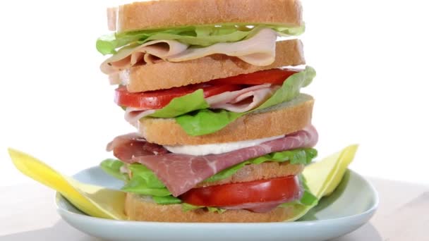 Sándwich alto con jamón, pollo, queso y tomate — Vídeo de stock