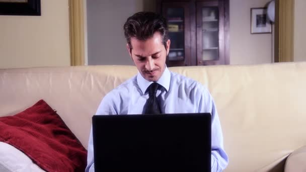 Empresario trabajando en el ordenador portátil en la sala de estar — Vídeos de Stock