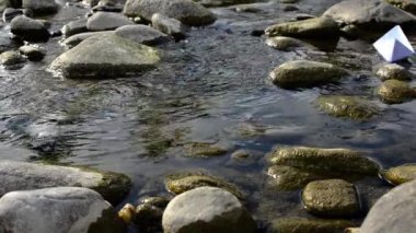 bir akış içinde yüzen kağıt tekne