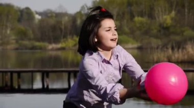 Çocuk fuşya bir topla oynamayı