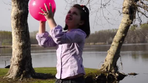 Jongen speelt met een fuchsia bal — Stockvideo