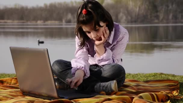 Bir çocuk, bir dizüstü bilgisayar ve bir göl — Stok video