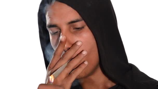 Nahaufnahme eines jungen Mannes, der Haschisch-Joint auf weißem Hintergrund raucht.