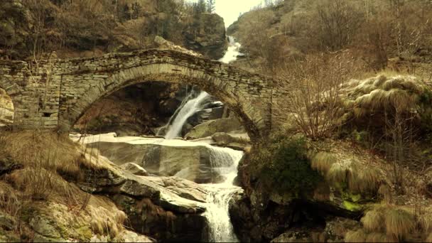 Cachoeira alpina e ponte antiga — Vídeo de Stock