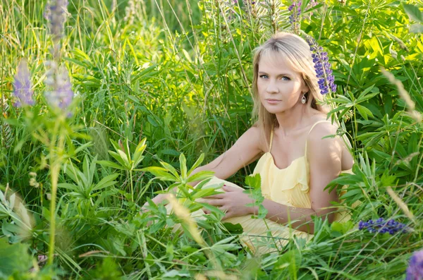 Jonge mooie vrouw in de lupine veld — Stockfoto
