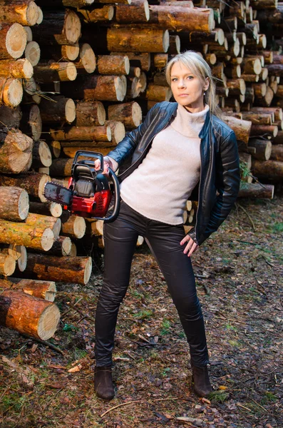 Jonge mooie vrouw met grote rode chainsaw — Stockfoto