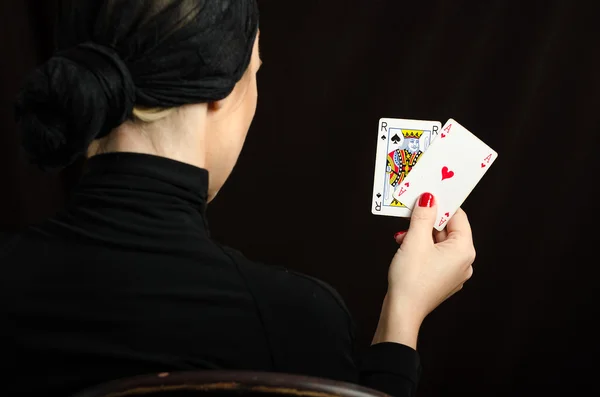 Vrouw in zwart met speelkaarten — Stockfoto