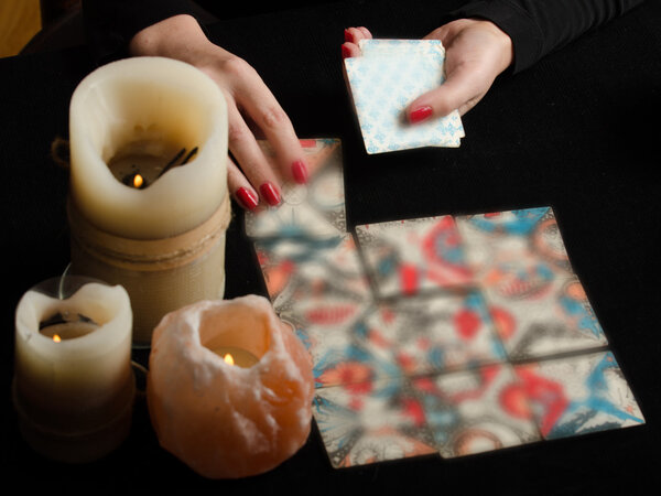 Hands of young woman with divination cards