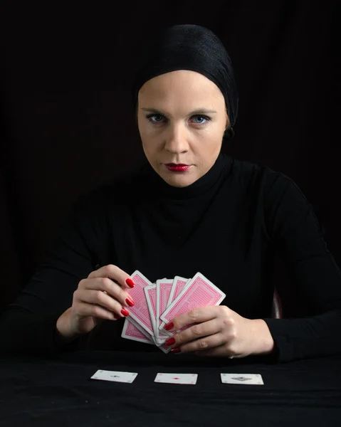 Vrouw in zwart met speelkaarten — Stockfoto