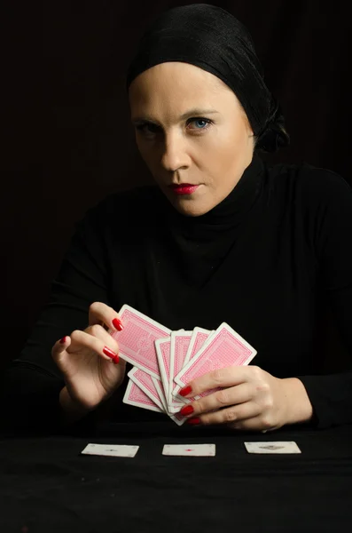 Vrouw in zwart met speelkaarten — Stockfoto