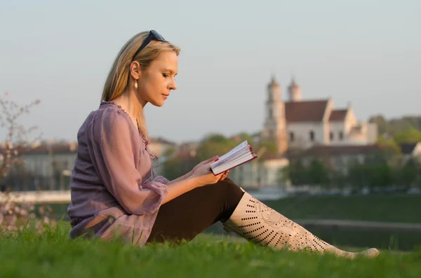 Νέα σέξι γυναίκα διαβάζοντας ένα βιβλίο στο Βίλνιους, Λιθουανία — Φωτογραφία Αρχείου