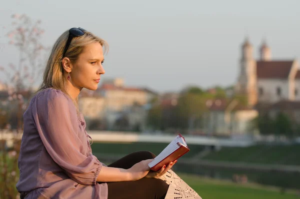 Νέα σέξι γυναίκα διαβάζοντας ένα βιβλίο στο Βίλνιους, Λιθουανία — Φωτογραφία Αρχείου