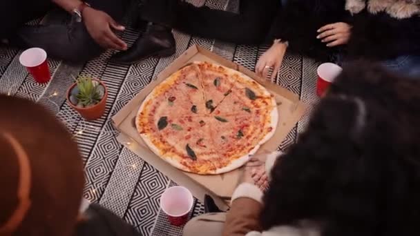 Grupo multi-étnico de amigos adultos comendo pizza fora da caixa de pizza em uma festa ao ar livre — Vídeo de Stock