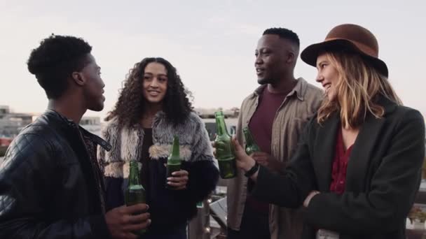 En grupp multietniska vänner som står på taket och firar, umgås och dricker. Högkvalitativ 4K-film — Stockvideo
