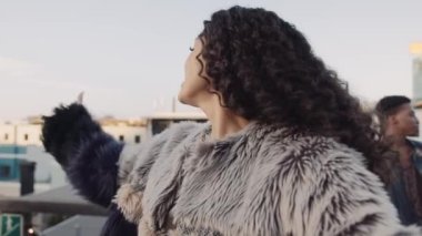 Kadın, çatıdaki akıllı bir telefondan selfie çekmek için farklı bir arkadaş grubunu arıyor. Yüksek kalite 4K görüntü.