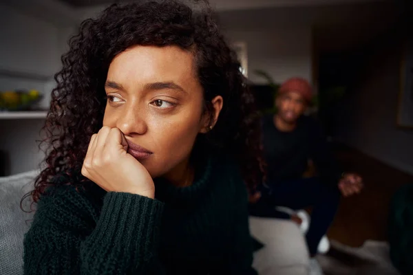 Close up de mestiço feminino ignorando namorado negro enquanto luta no sofá no apartamento moderno — Fotografia de Stock