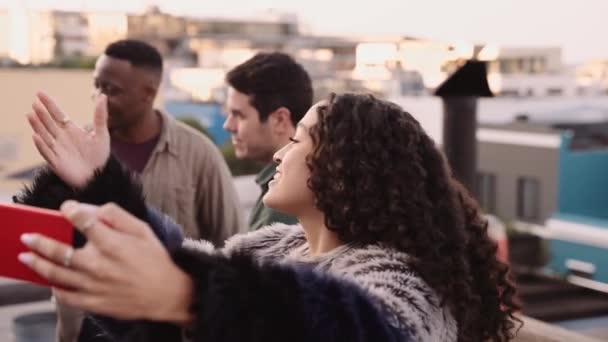 Багатокультурна жінка закликає своїх друзів взяти селфі на даху в місті в сутінках — стокове відео