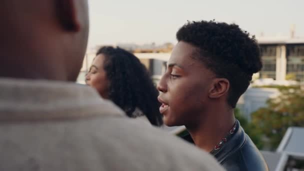Чорні дорослі чоловіки спілкуються між різноманітною групою друзів на вечірці на даху міста — стокове відео
