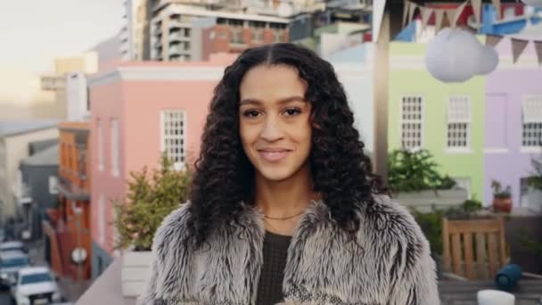 Multikulturní žena se za soumraku usmívá na kameru na střeše města. Barevná městská krajina v pozadí — Stock video