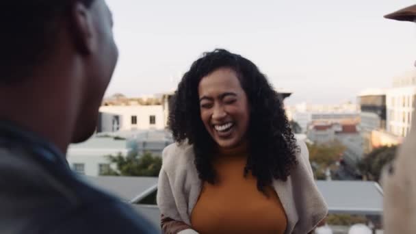 Multi-cultural female socializing with a diverse group of adult friends at rooftop party. Chatting lightheartedly at dusk. High quality image. — Stock Video