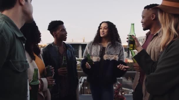 Grupo de amigos multiétnicos em pé no telhado socializando com bebidas à noite. Imagens 4K de alta qualidade — Vídeo de Stock