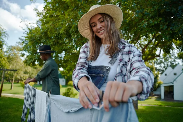 Caucásico agricultor femenino pegging ropa sucia en línea de lavado —  Fotos de Stock