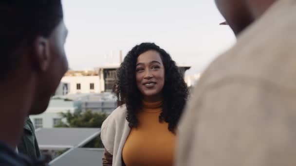 Femme multiculturelle parlant à son groupe diversifié d'amis adultes à la fête sur le toit dans la ville. — Video