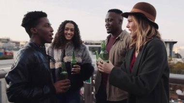 Çatıda durmuş kutlama yapan, sosyalleşen ve kadeh kaldıran bir grup çok ırklı arkadaş. Yüksek kalite 4K görüntü
