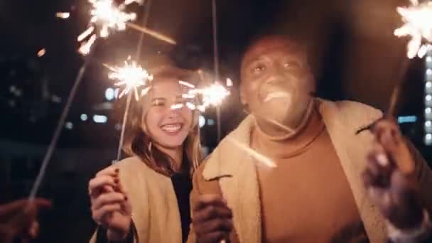 Vielfältige Freunde feierten und lachten mit Wunderkerzen im Freien in der Nacht. Hochwertiges 4K-Filmmaterial — Stockvideo