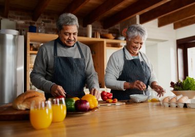 Modern mutfakta yemek hazırlayan çok kültürlü yaşlı çift. Evde sağlıklı yiyecekler yemek, izole etmek..