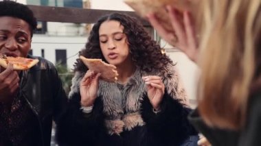 Çok kültürlü kadınların sosyalleşmesi, pizza yemesi ve şehrin alacakaranlığında çatıda çeşitli yetişkin arkadaşlarla sohbet etmesi.