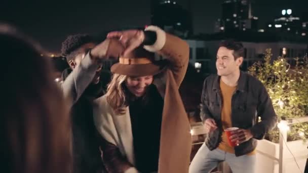 Black male and caucasian female dancing together in the centre of a circle of diverse group of friends at a rooftop party in the city. — Stock Video