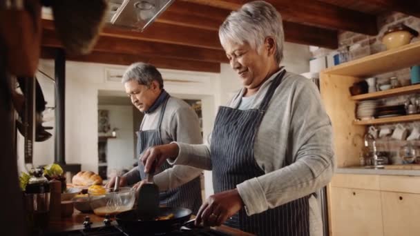 Mujer anciana multicultural cocinando en la cocina, ayudado por el marido. Socios felizmente jubilados — Vídeos de Stock