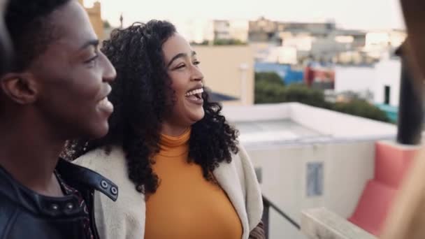 Mezcla de raza femenina sonriendo y riendo con diversos grupos de amigos adultos en una azotea de la ciudad — Vídeos de Stock