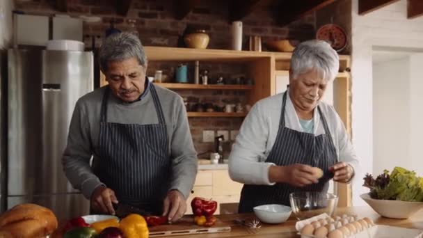 Casal de idosos multiculturais cozinhar café da manhã juntos na cozinha moderna. Felizmente aposentado, conversando — Vídeo de Stock