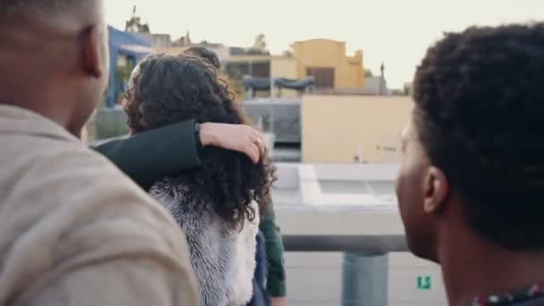 Şehirdeki bir çatı partisinde çok ırklı bir arkadaş grubunu karşılayan melez bir kadın. — Stok video